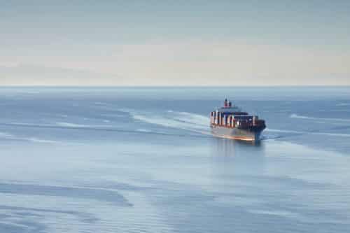 Shaft power limitation system. Distant aerial photo of a loaded container ship at sea.