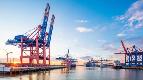 Row of large port cranes are waiting to load and unload the container ships