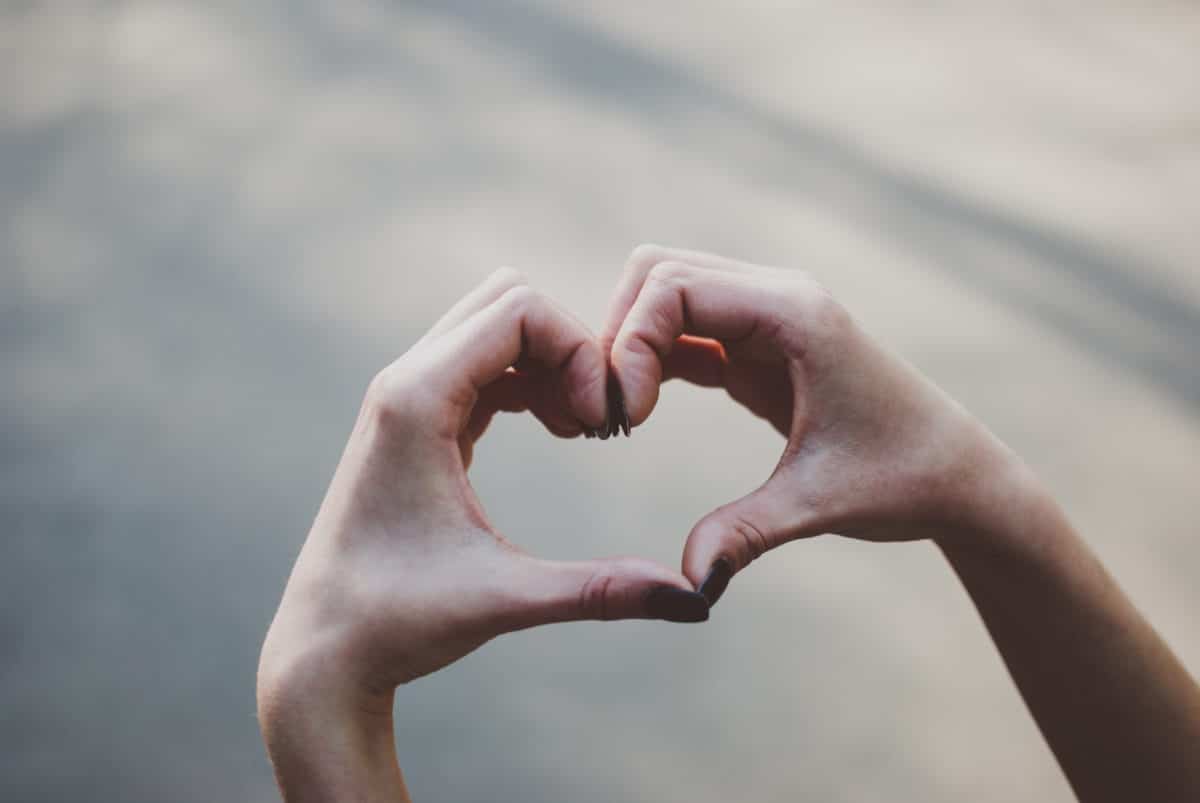 Social Impact Initiatives. Girl making a heart shape gesture